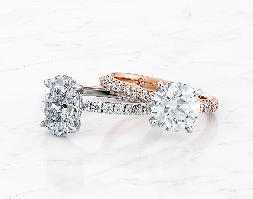 Two diamond engagement rings laying next to each other